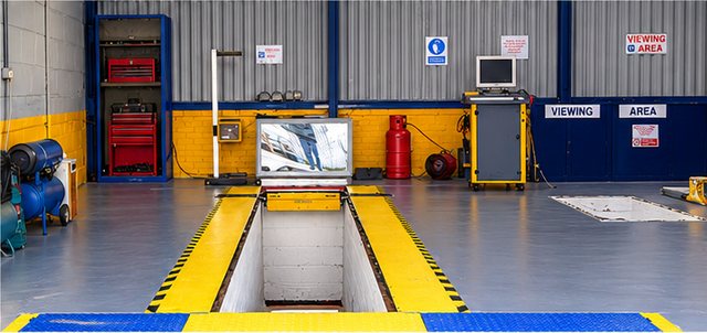 The MOT test bay with its inspection pit, and the customer viewing area behind